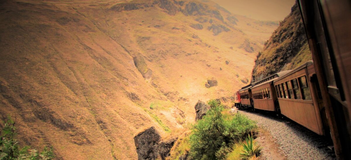 Old fashioned train looking precarious on a narrow mountain pass