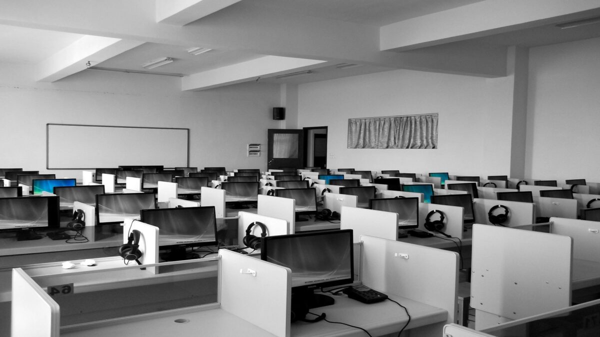 Desks with computers and phones at a call centre.