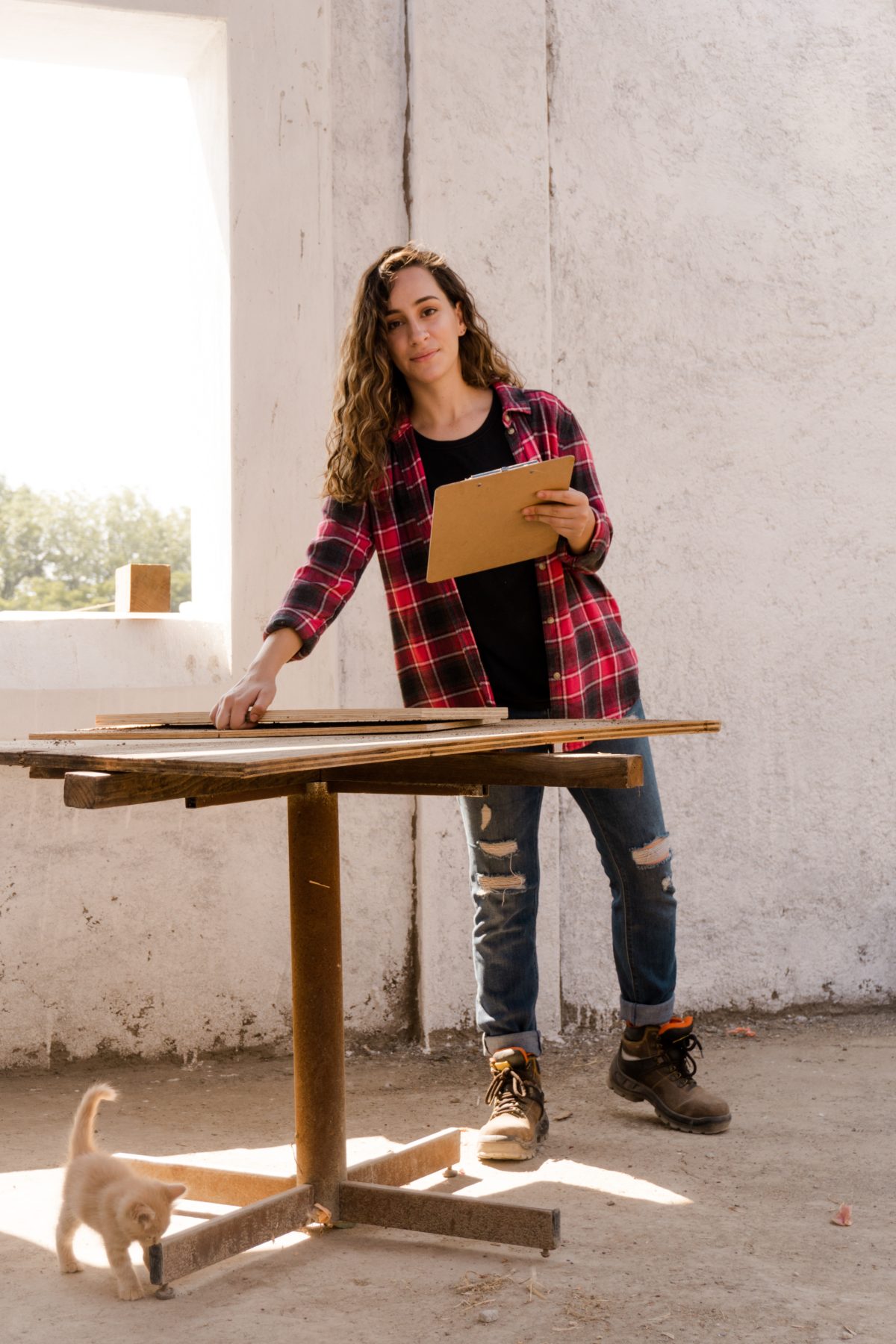 Young woman standing over table on a construction project holding documentation