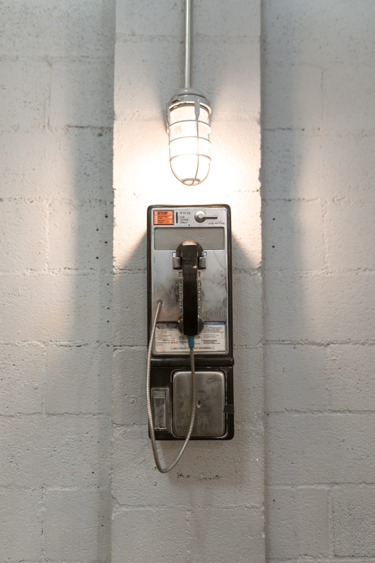 Payphone on jailhouse wall.