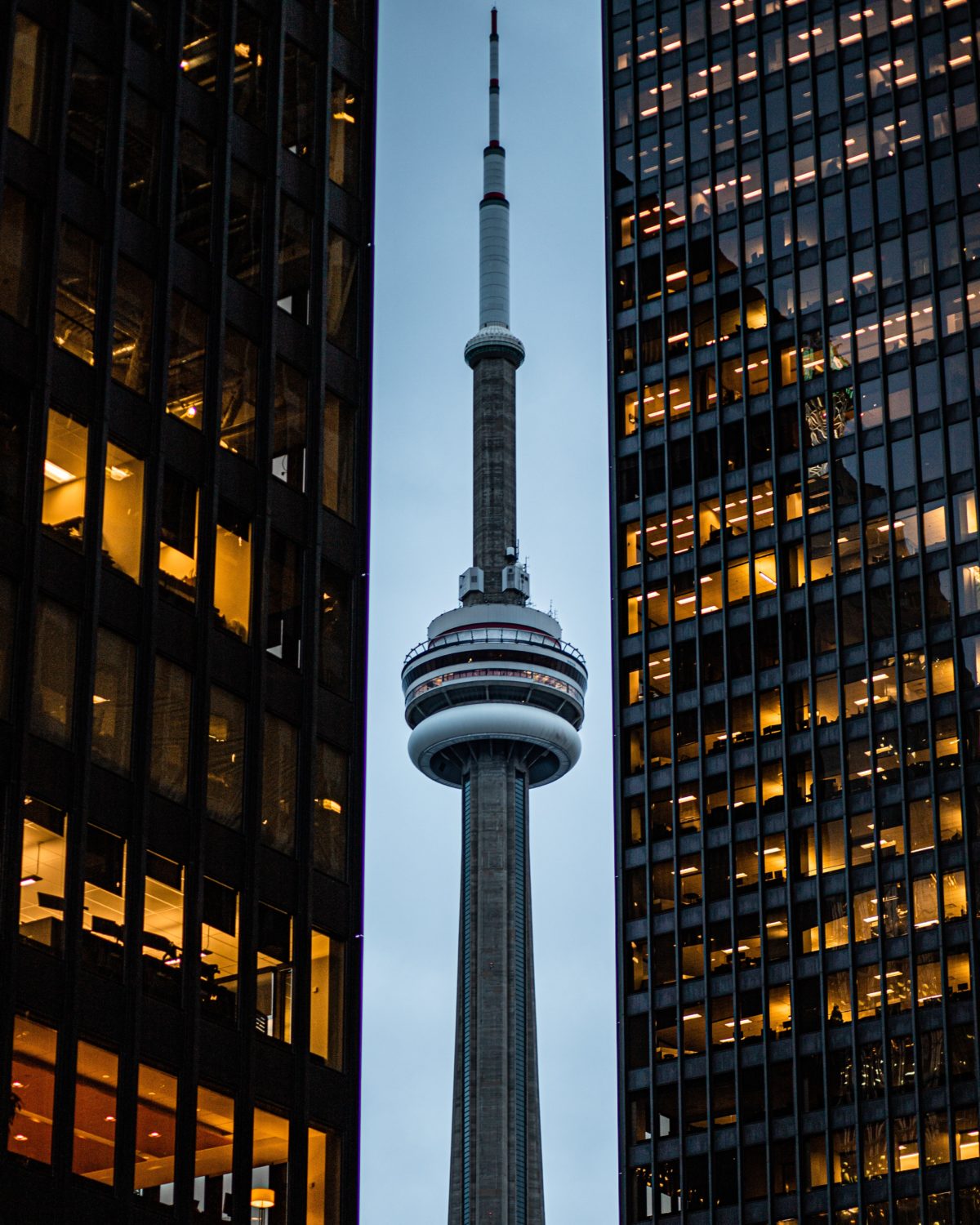 Toronto's CN Tower flanked by office towers on either side.