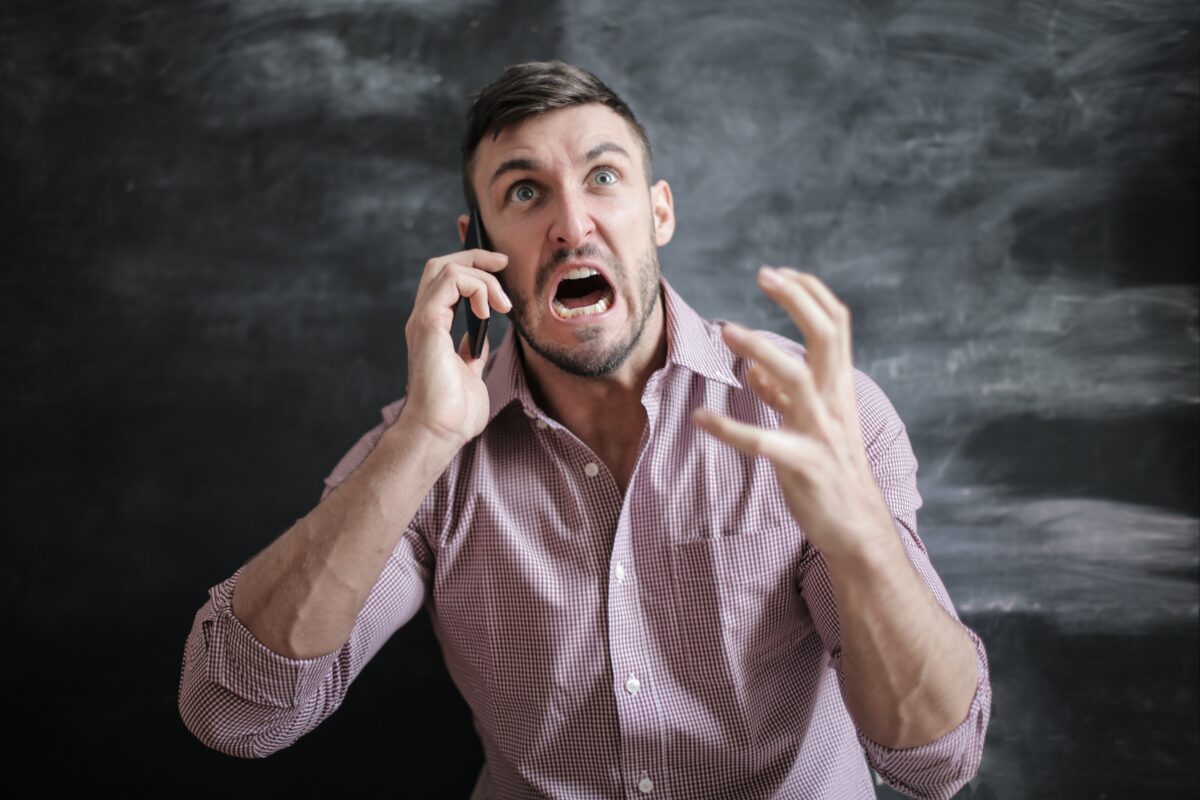 Man with phone looking stressed.