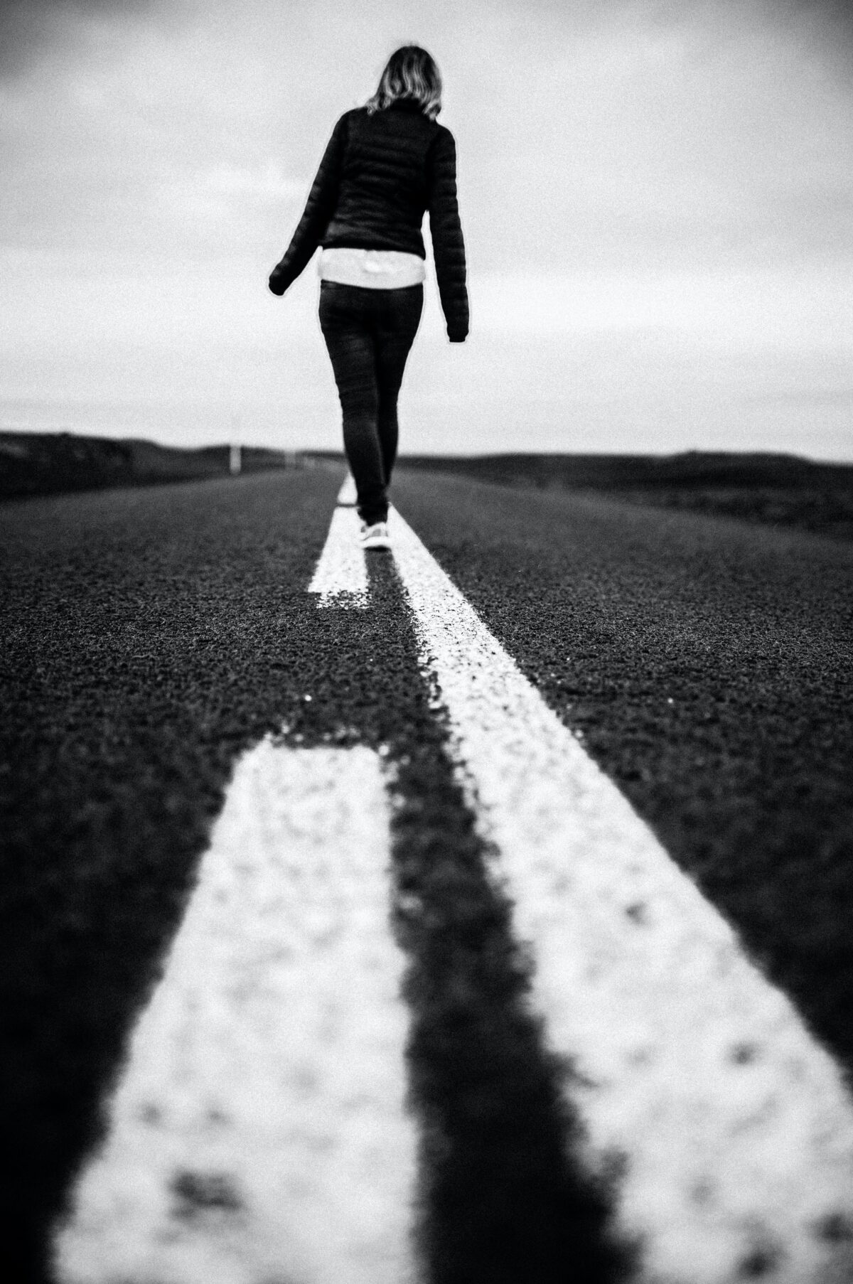 Person walking on the center line of the highway.