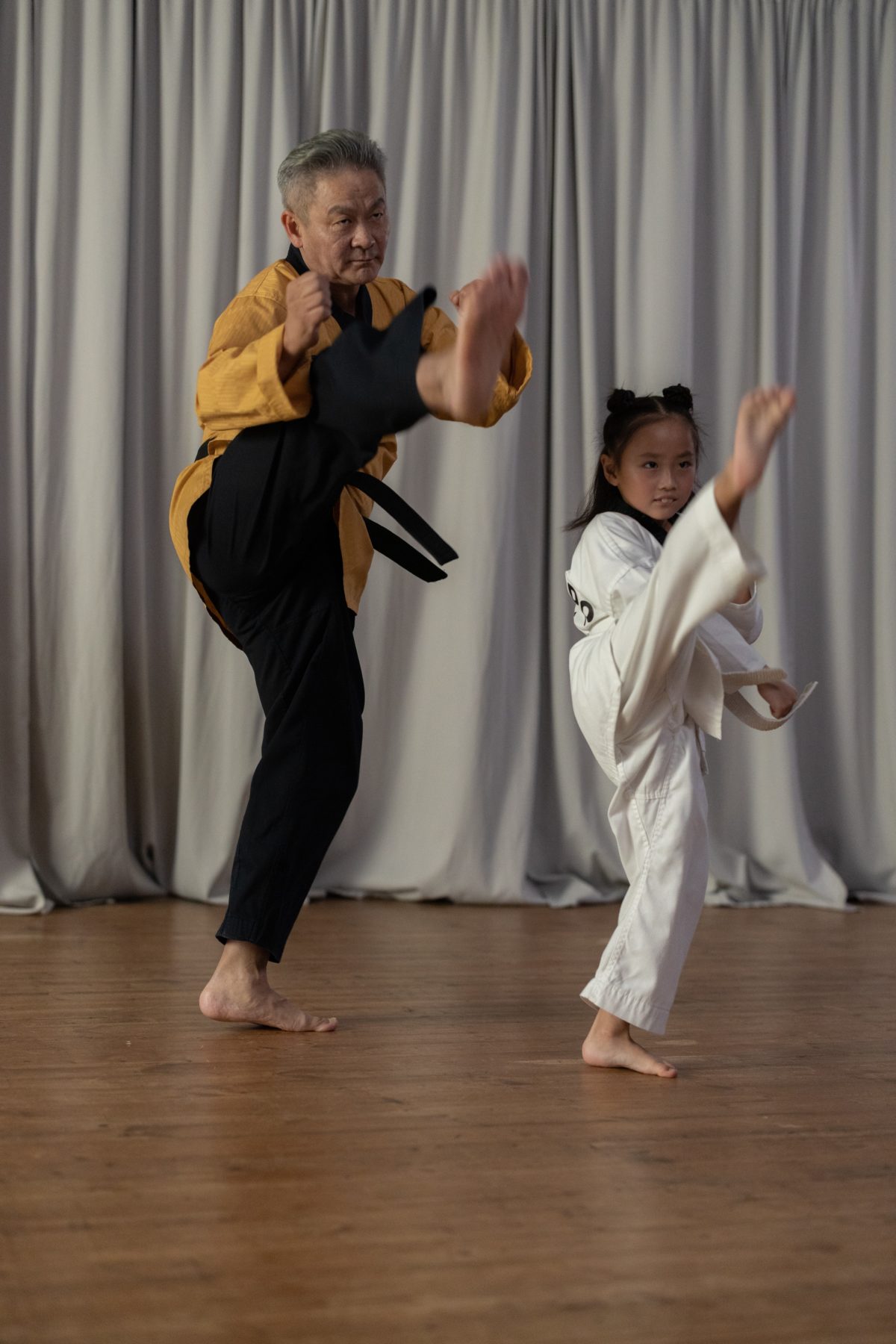 Sensei and young student learning a Karate kick.