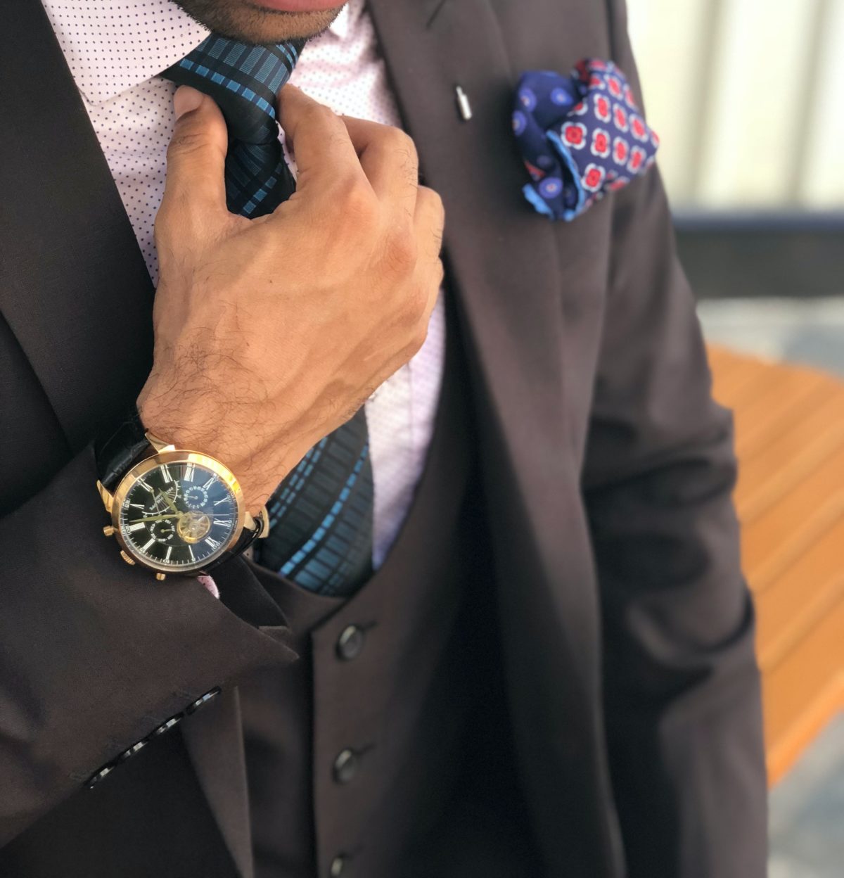 A man formally dressed with a fancy watch and a pocket handkerchief.