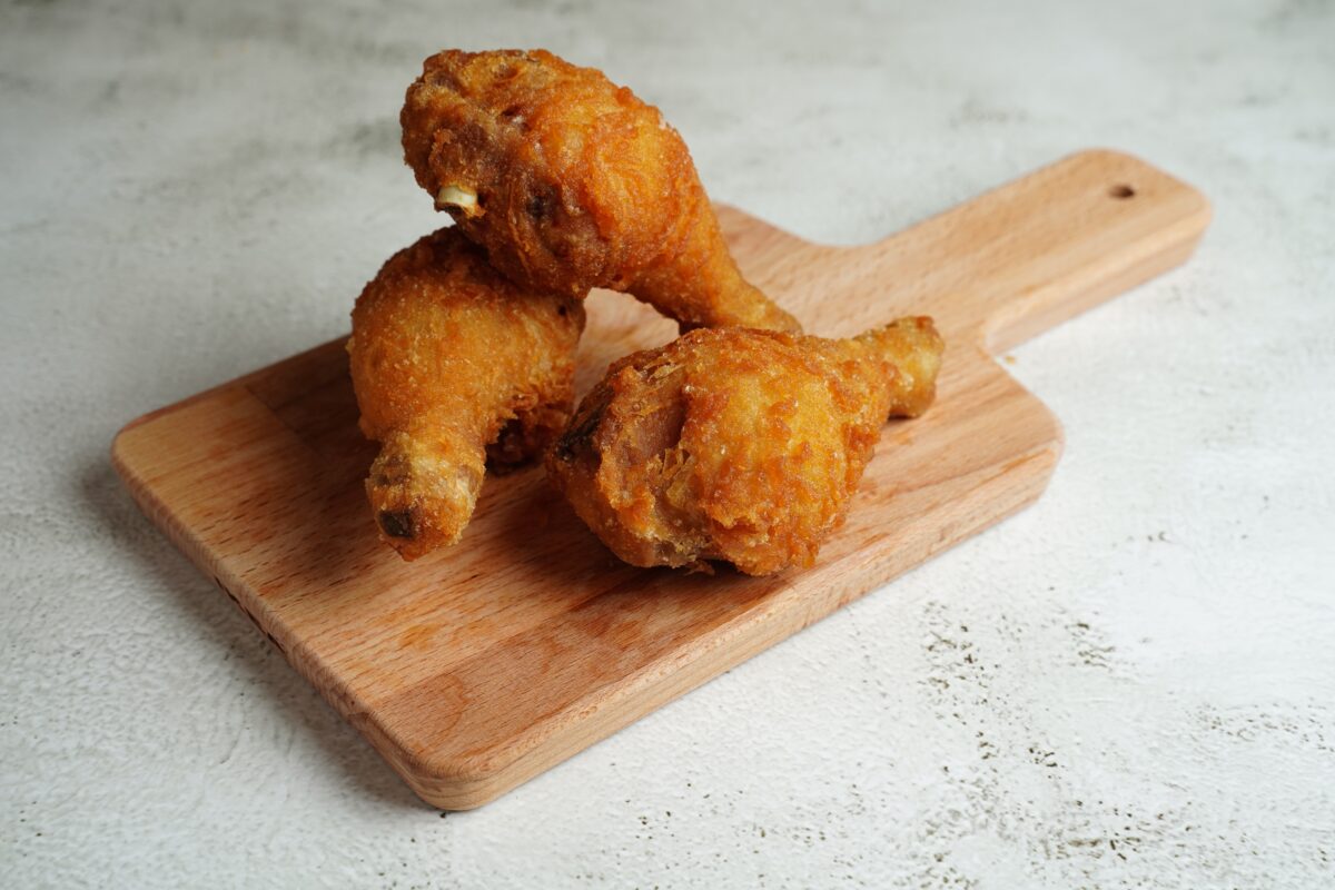 Fired chicken legs on a wooden board.