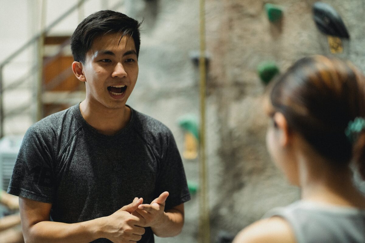 Man speaking to woman. Photo by Allan Mas at Pexels.