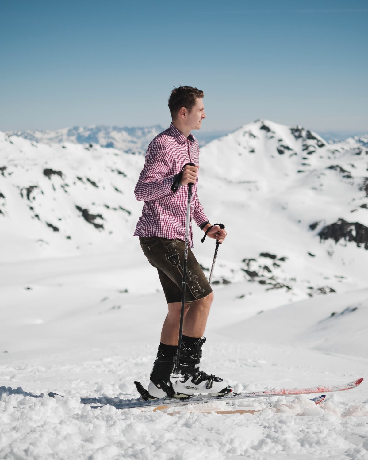 Young man skiing wearing a shirt and shorts.