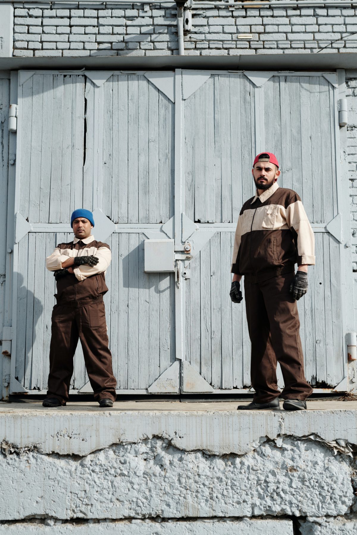 A large man and a small man standing in front of an industrial door.