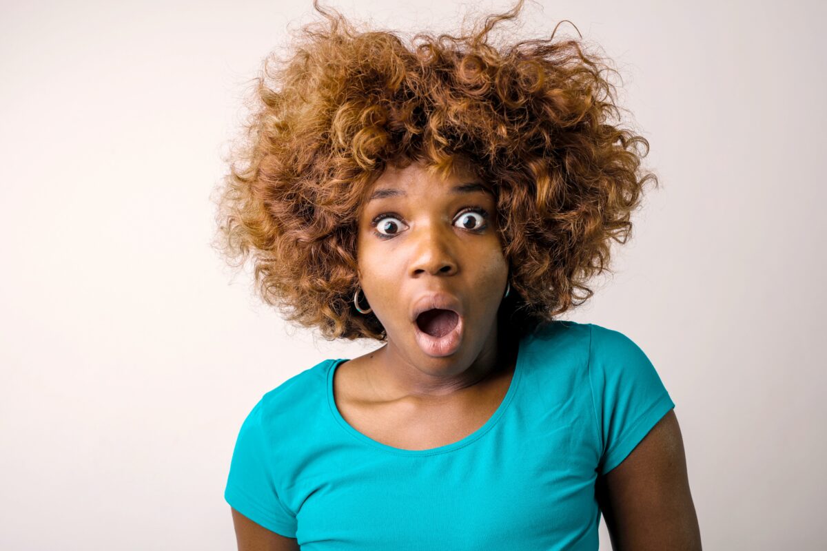 photo-of-shocked-woman-in-blue-t-shirt-standing-in-front-of-white-background-