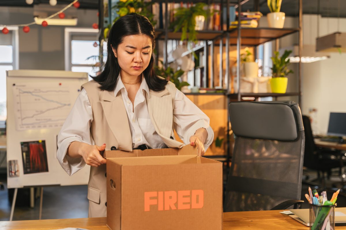 Woman packing a box marked "Fired"