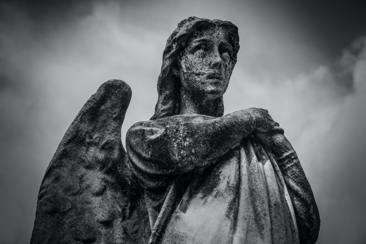 A somber looking stone angel.