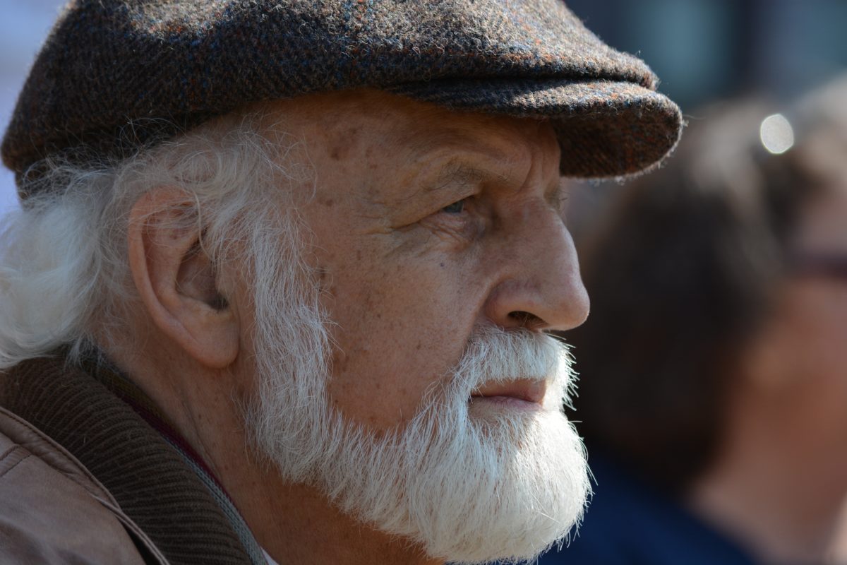 Older man with a white beard and a cap.
