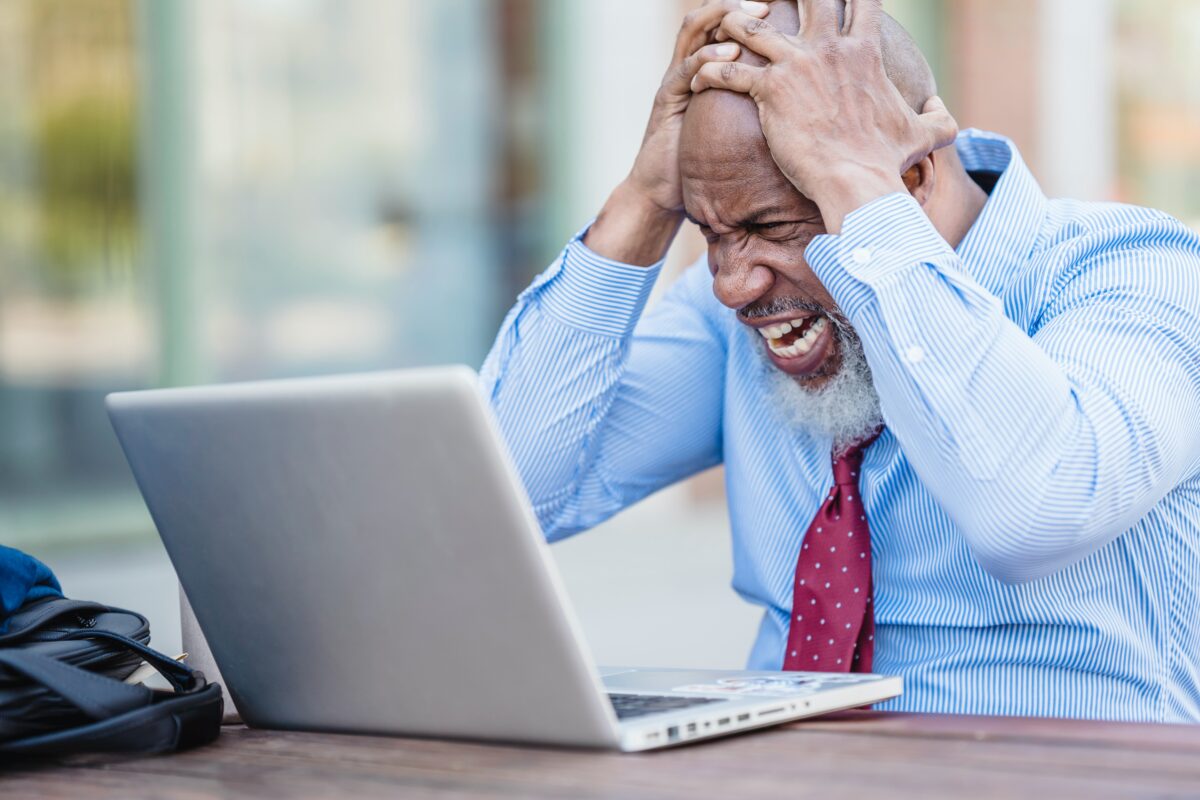 Frustrated man in front of a laptop.