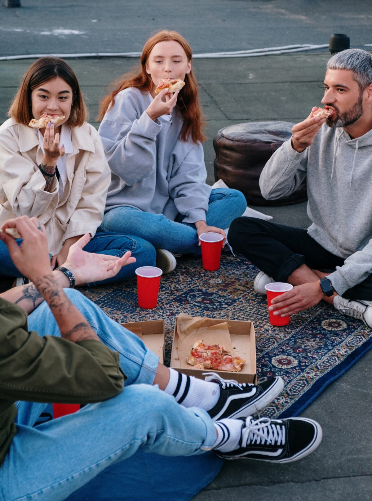 A group of young people eating pizza.