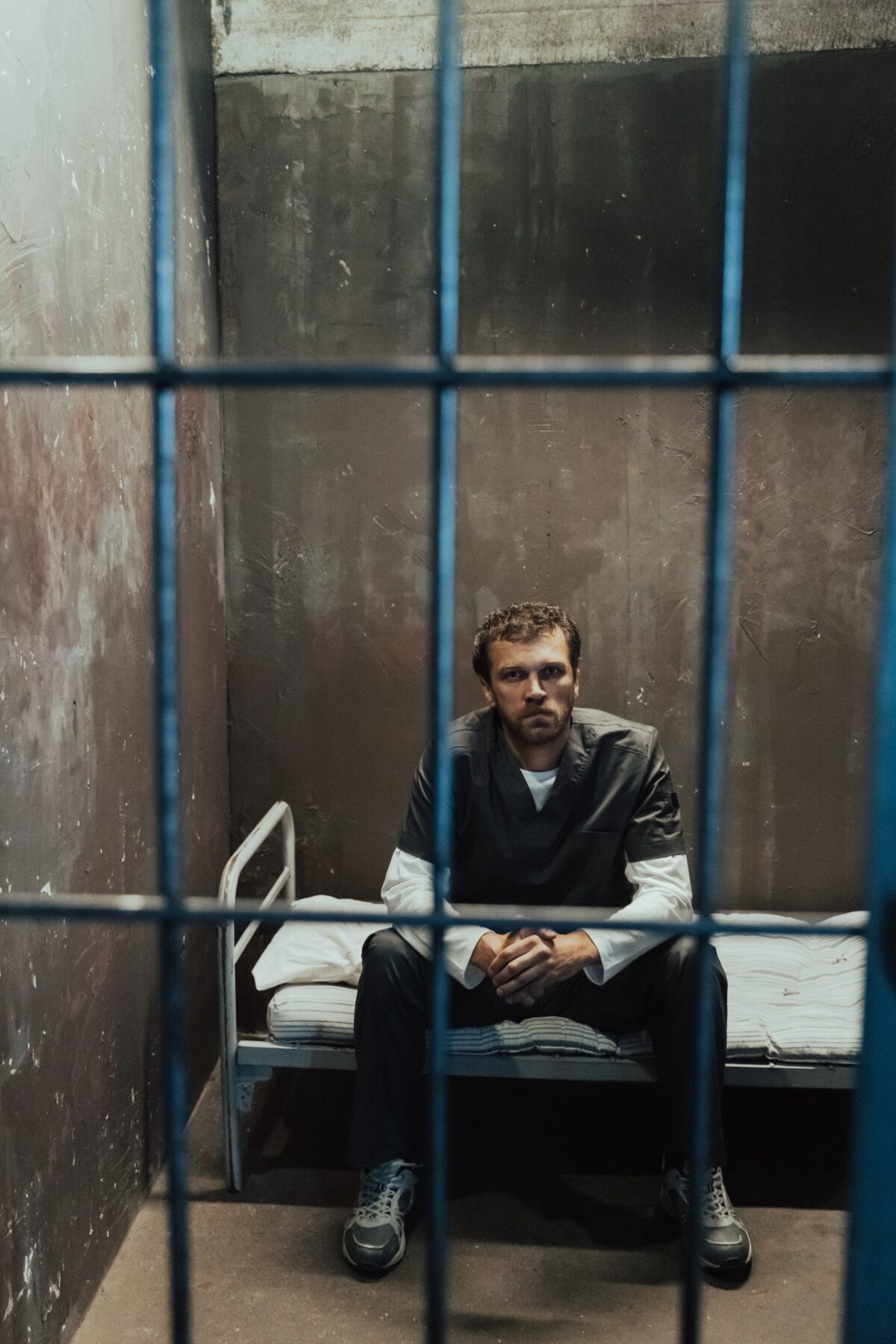 Man sitting in a jail cell.