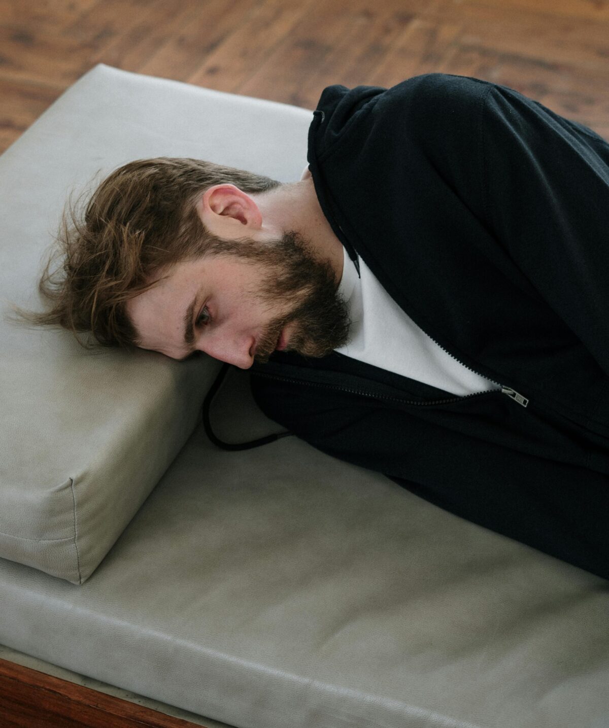 Man lying down, fully dressed.