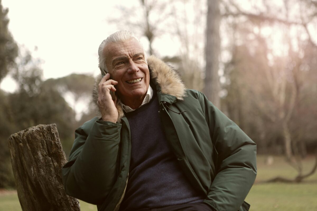 An older white man talking on his phone.