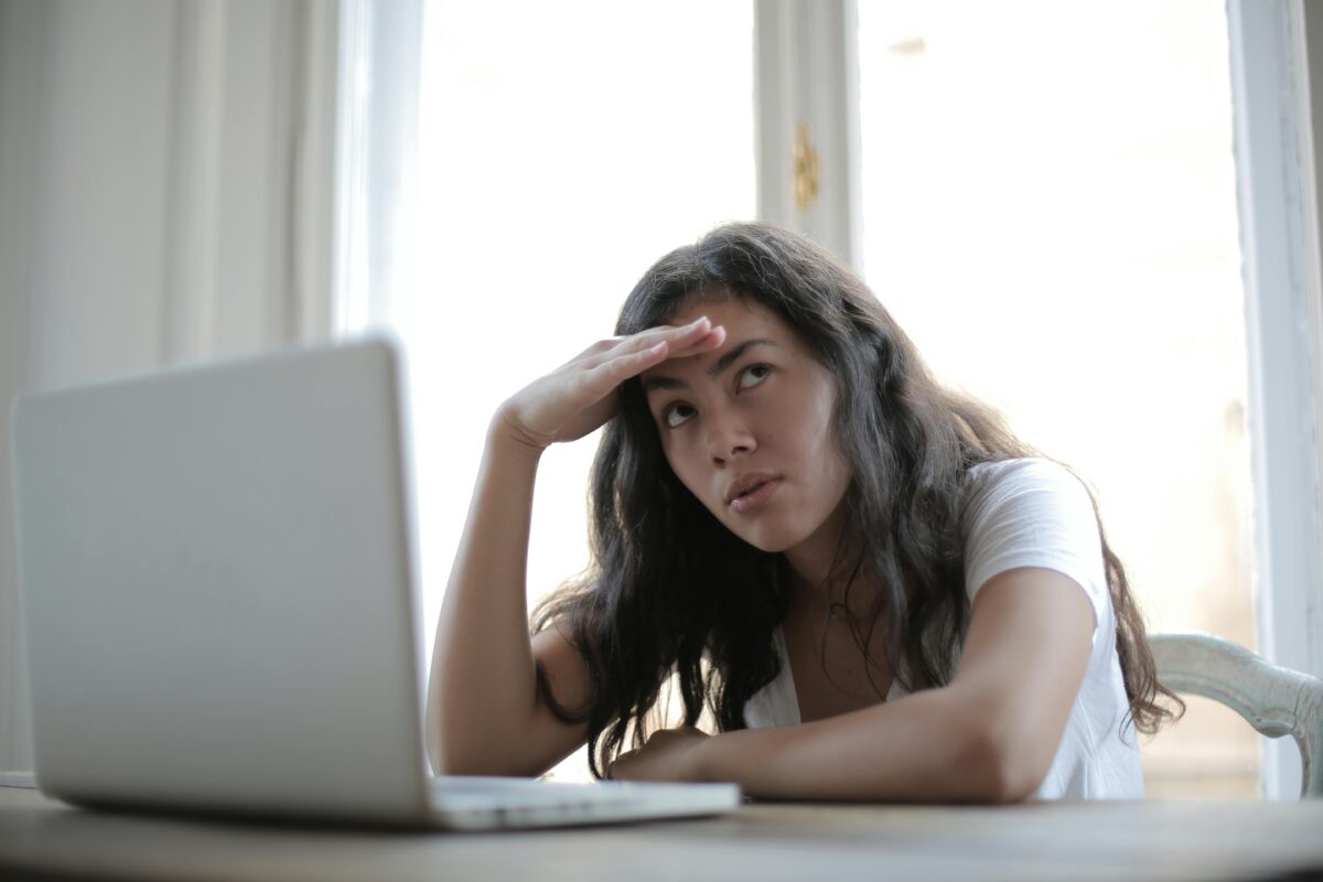 Woman sitting at computer looking unhappy.