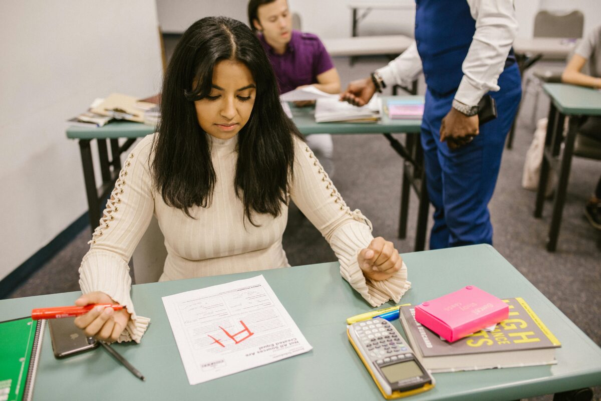 Woman looking at grade on paper at school.
