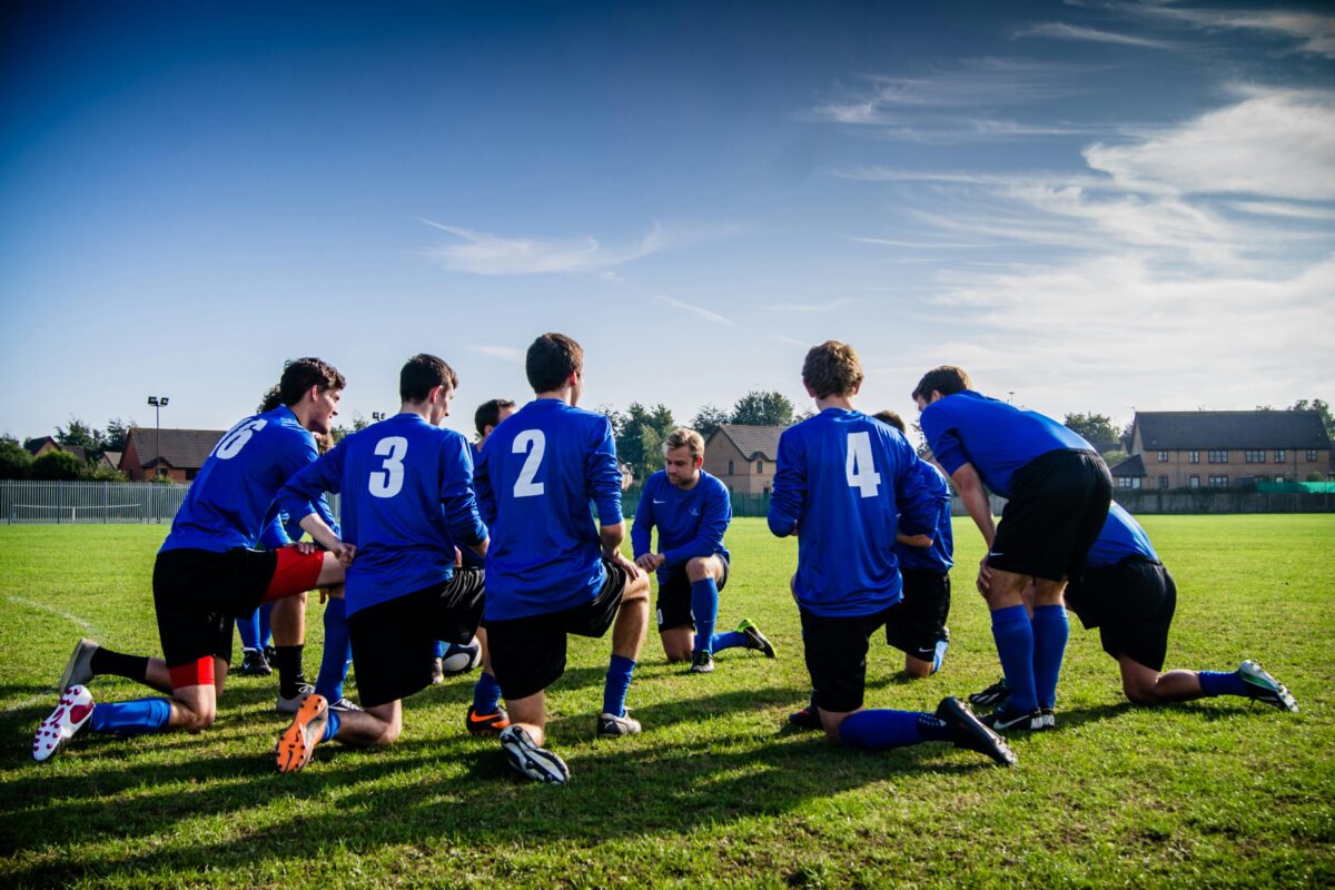 A rugby team kneeling in a circle.