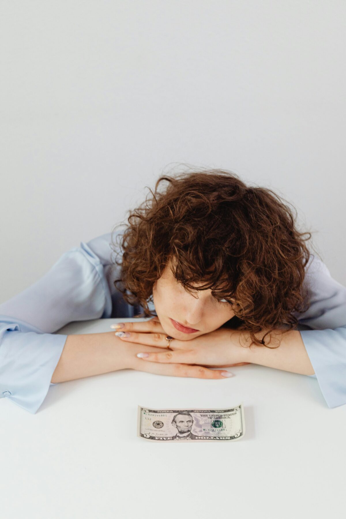 Woman staring at dollar bill.