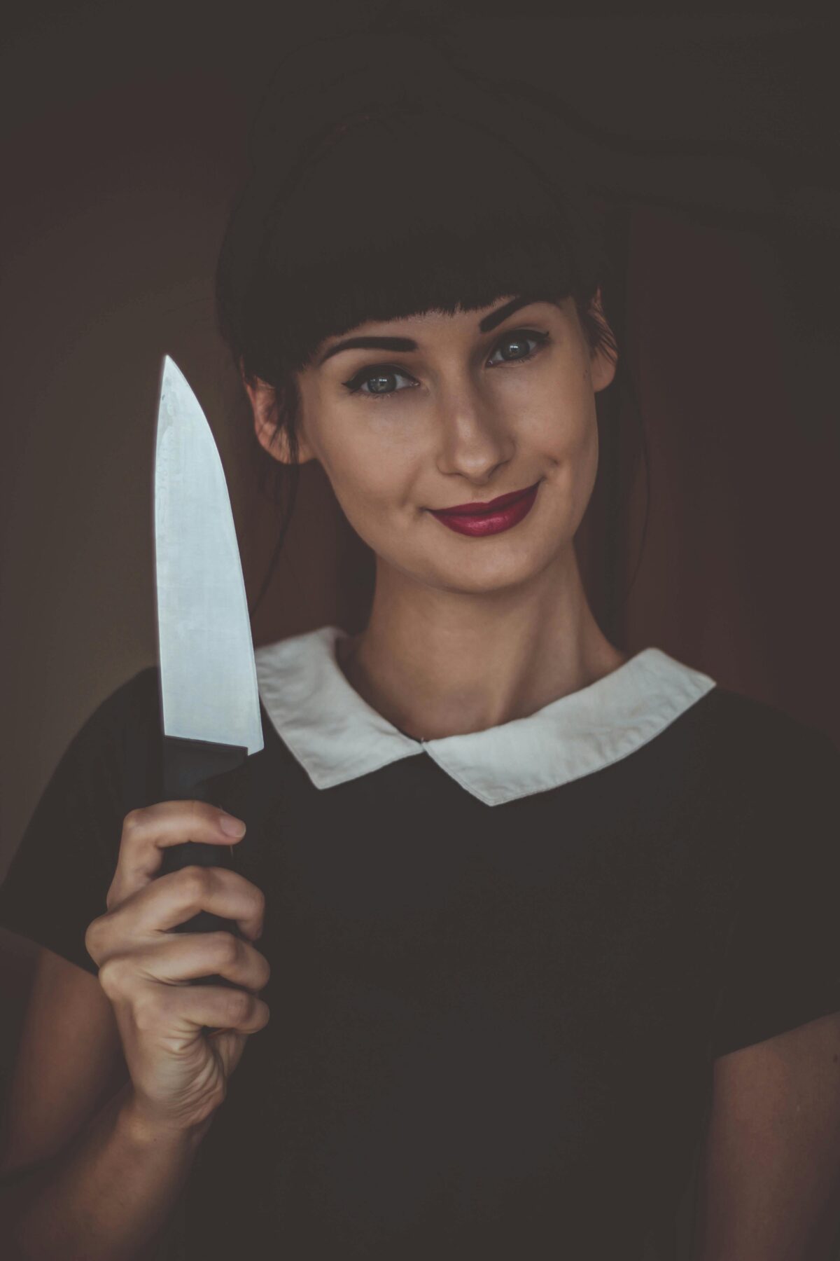 Smiling woman holding an knife.