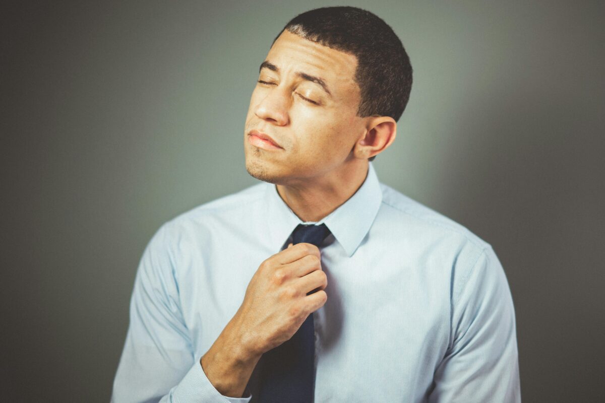 A man in a shirt and tie looking stressed.