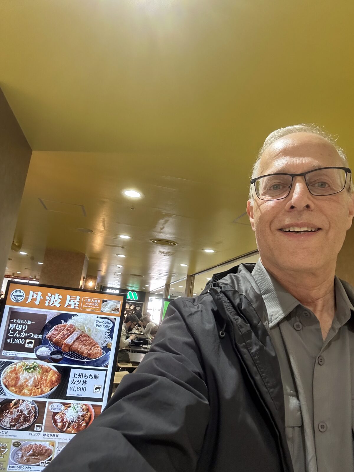 The author in Japan standing in front of a Japanese restaurant sign.
