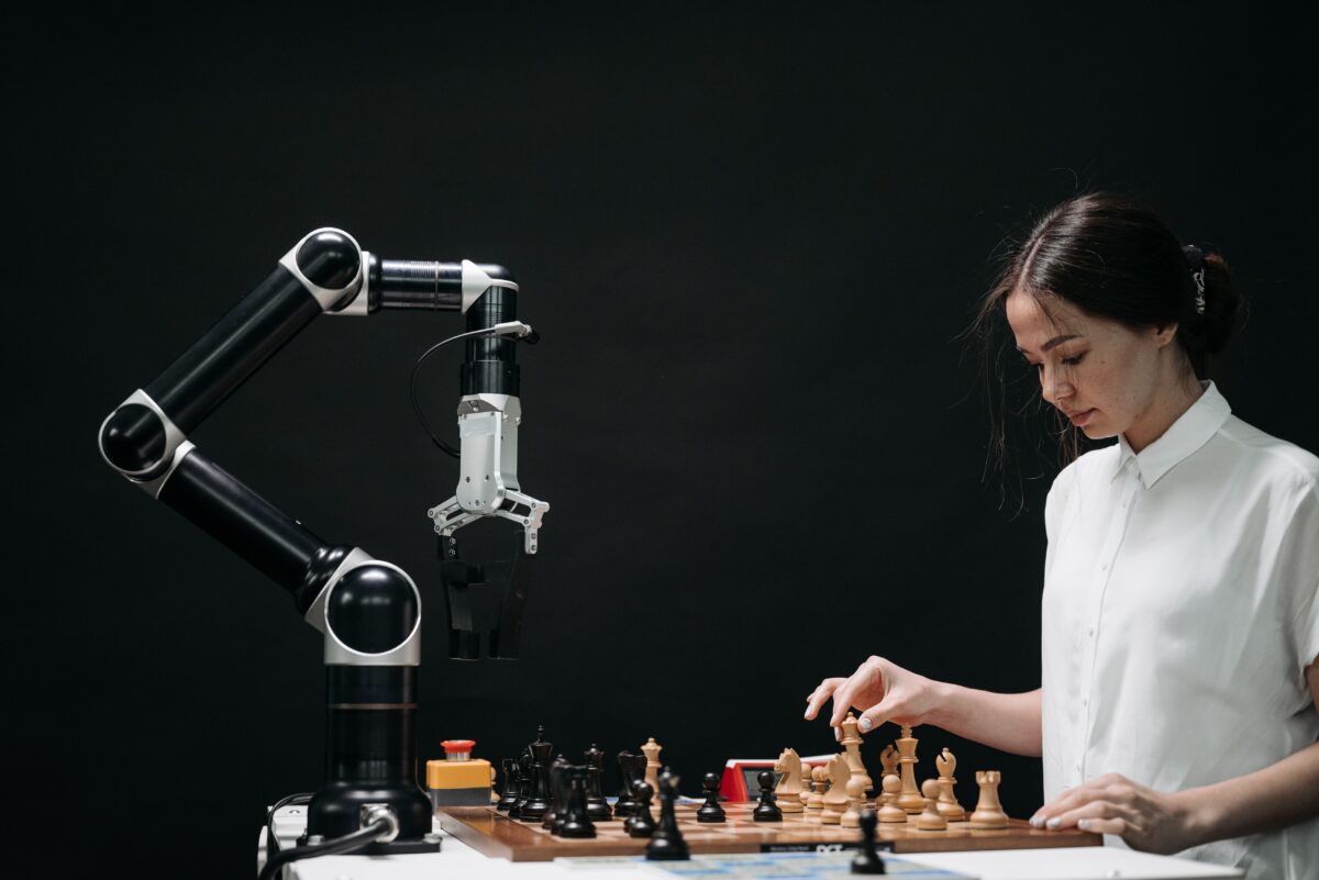 A Woman playing chess with a computer.