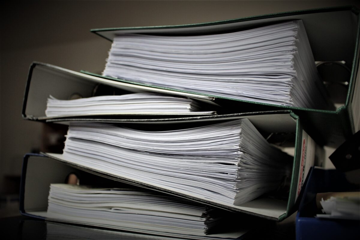 A stack of binders full of paper.